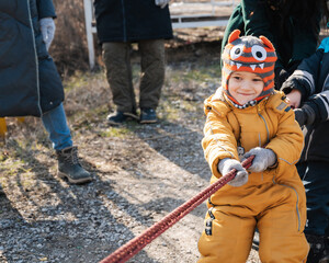 baby boy playing tug of war on Shrovetide