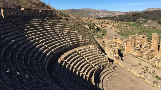 High-angle footage of a tourist in the theatre of the ancient Roman town of Djemila. Setif, Algeria. UNESCO World Heritage Site.
