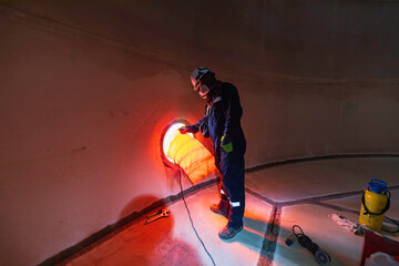 Male worker inside the  tank storage visual inspection tank into the confined space is the blower