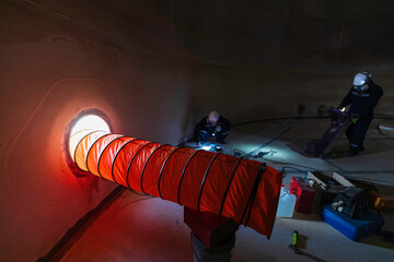 Male worker inside the  tank storage visual inspection tank into the confined space is the blower