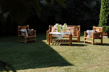 Elegant garden furniture on the terrace of a country house. Wooden wicker garden furniture. Beauty and peace near the house.