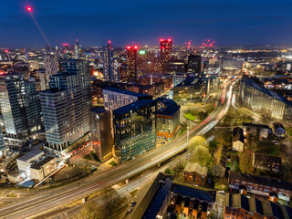 Fototapeta na wymiar Aerial image of Manchester skyline early night showing new urban developments and trail of lights from the traffic. 