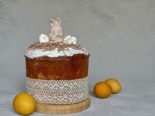 Yellow eggs and a traditional Easter cake with white icing sugar and chocolate figures in the shape...