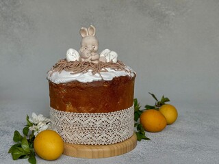 Yellow eggs and a traditional Easter cake with white icing sugar and chocolate figures in the shape...