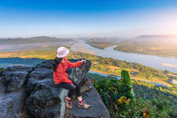 Asian female tourist sits and admires the view at Pha Tak Suea, Thai-Lao border - 721997446