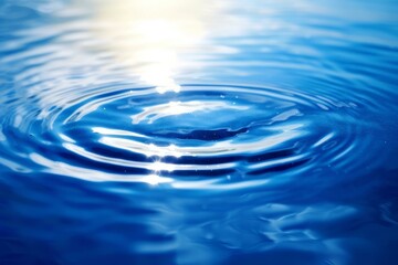 Water surface with ripples and a drop of water falling in slow motion