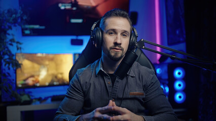 Gamer influencer streaming live talking to fans with game playing in background © Video_StockOrg