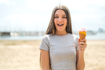 Teenager girl with a cornet ice cream at outdoors with surprise and shocked facial expression - obrazy, fototapety, plakaty