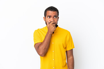Young Ecuadorian man isolated on white background having doubts and with confuse face expression