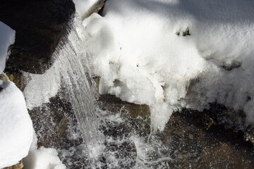 The end of winter. Stormy flow of water in a mountain river, close up.