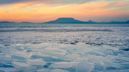 onyod, Hungary - Beautiful icebergs on the shore of the frozen Balaton. Badacsony and Gulacs with a...