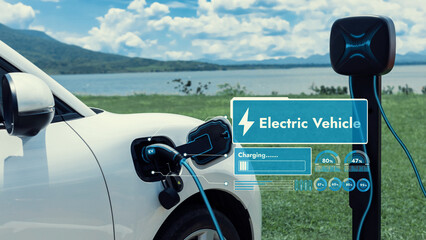 Electric car plug in with charging station, recharge battery by EV charger cable display smart digital battery status hologram with nature background. Futuristic green energy infrastructure.Peruse