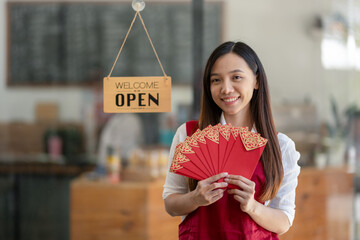 Asian female employee holding a red envelope or red envelope on Chinese New Year, a festive gift