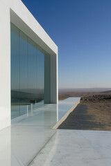 In a desert, there is a modern minimalist building.