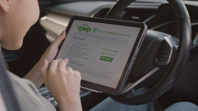 Asian people woman buyer read cover legal policy form look at cost price buy EV motor insure premium on web page touch screen mobile app sitting inside car. Go green lifestyle protect car driver owner