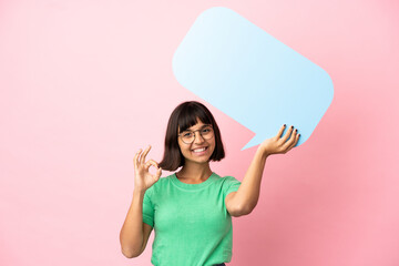 Youing woman holding an empty speech bubble and doing OK sign - obrazy, fototapety, plakaty