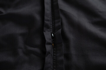 Texture of black crumpled cotton fabric with zipper