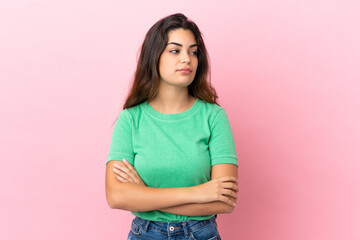 Fototapeta premium Young caucasian woman isolated on pink background looking to the side
