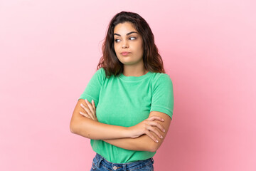 Young caucasian woman isolated on pink background making doubts gesture while lifting the shoulders
