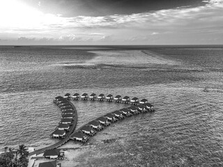 Aerial view from the drone of bungalows on the water, tourist village in maldives. - 722039251