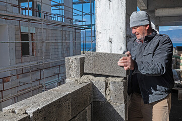 A construction worker building a wall with mortar.