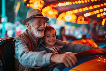 Deurstickers A joyous moment captured between generations as an elderly man and a young boy share a genuine smile while wearing their street clothes and matching sun hats at a bumper car ride © Pinklife