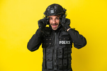 SWAT caucasian man isolated on yellow background with glasses and surprised
