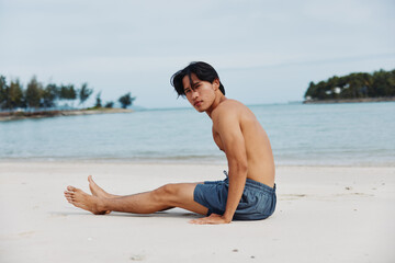 Fototapeta na wymiar Muscular Asian Athlete Enjoying a Sunset Beach Run in Fitness Lifestyle