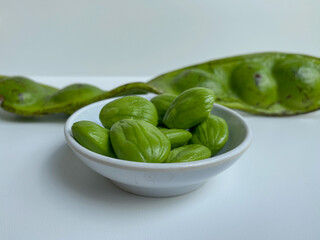 Parkia speciosa, the bitter bean, petai, or pete. Before and after peeled. Isolated on white background