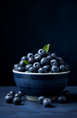 medium format shot of blueberries piled on top in a bowl on a dark blue surface, in the style of monochromatic minimalist portraits сreated with Generative Ai