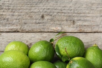Fresh limes on wooden table, top view. Space for text
