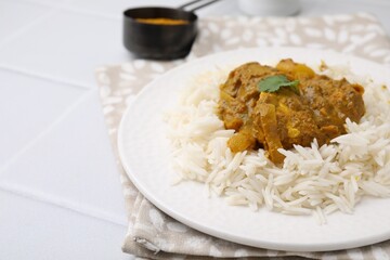 Delicious chicken curry with rice on white tiled table, closeup