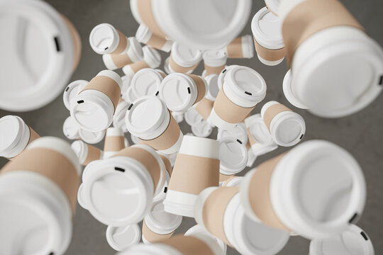 A lot of disposable white paper coffee cups with white lid and sleeves made from cardboard falling onto a gray floor. Top down view. Waste concept due to disposable containers