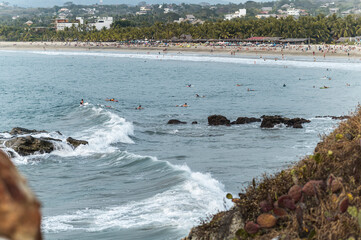 Surfers calmly await waves in the serene waters off the coast of Puerto Escondido, Oaxaca, Mexico