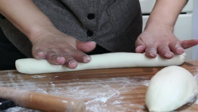 Making traditional Chinese dumplings,roll the dough into a long stick