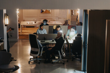 Team collaboration and discussion in modern office environment at night.