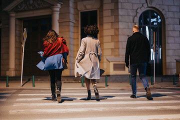 Friends walking at night in urban setting, casual evening stroll.