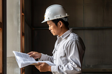 portrait of asian construction worker using a drill on white background