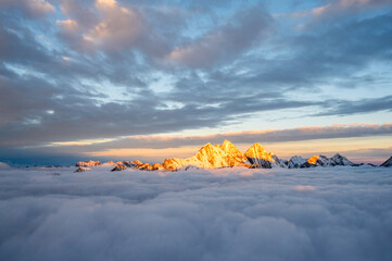 Mount Siguniang, Four Girls Mountain the Sacred Mountain in the East, National Geo-park of China, Sunset over a sea of clouds in the mountains with golden light touching snowy peaks