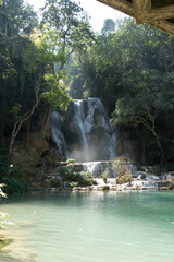 Majestic waterfall cascading into a serene pool surrounded by lush vegetation