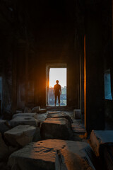 Silhouette of a person standing at the door during sunset