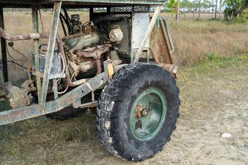A close-up look of the engine and front wheel of a swamp buggy including the chassis transmission...