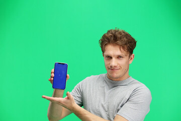 Man, on a green background, close-up, with a phone