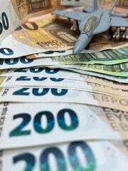 Closeup of euro banknotes with a fighter plane on the background. 50 EURO 200 EURO