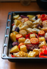 Close up image of a delicious and healthy looking tray with roasted colourful root vegetables fresh from the oven in a sunlit kitchen