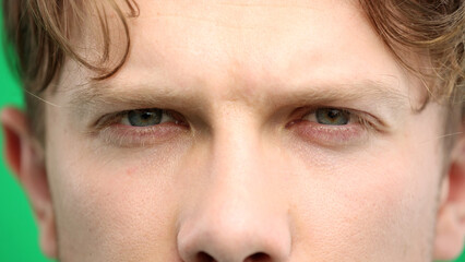 Obraz premium Man's eyes, close-up, on a green background
