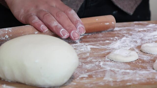 Making traditional Chinese dumplings,Roll out dumpling wrappers on wooden board