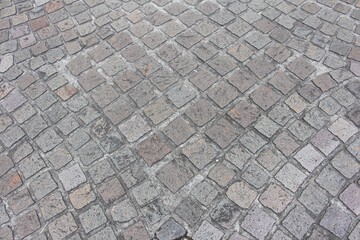 Texture of cobblestone. Pattern of sidewalk tiles in the street. Cobblestones close up.