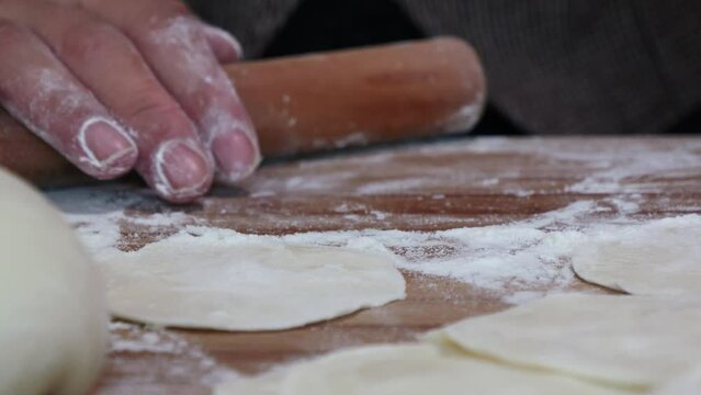 Making traditional Chinese dumplings,Roll out dumpling wrappers on wooden board
