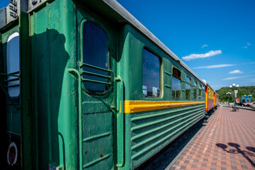 A train of old wagons on the platform of the railway station.